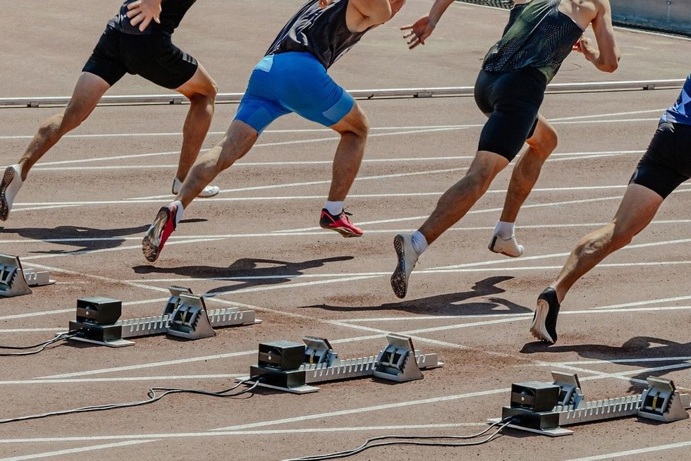 Sprinters take off from the starting blocks