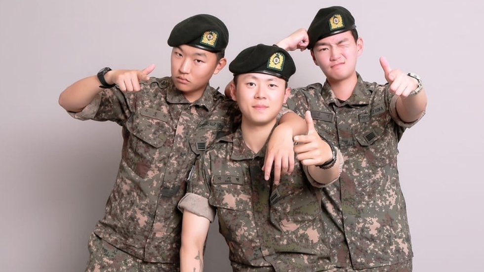 Three young soldiers in uniform mug for the camera