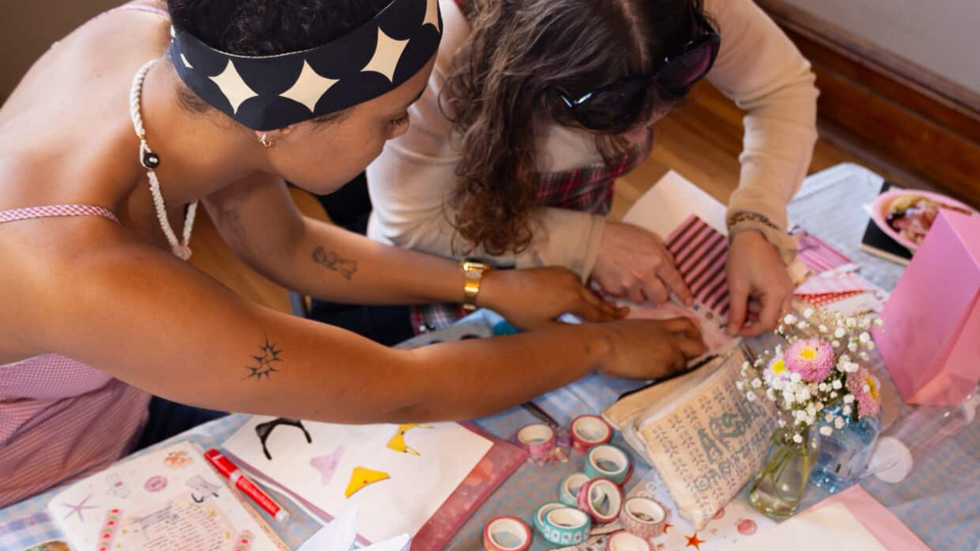 Two girls crafting their journals together.