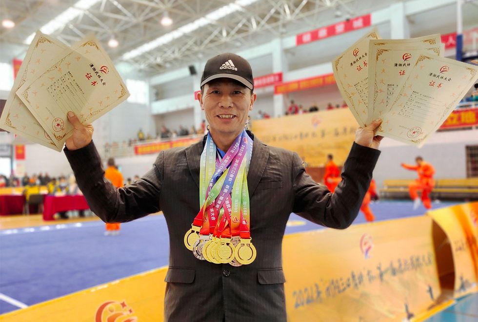 Wushu coach Wang displays the seven medals his students won in a tournament.
