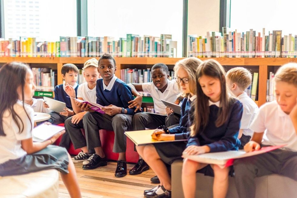 Young students in uniform sitting in a library
